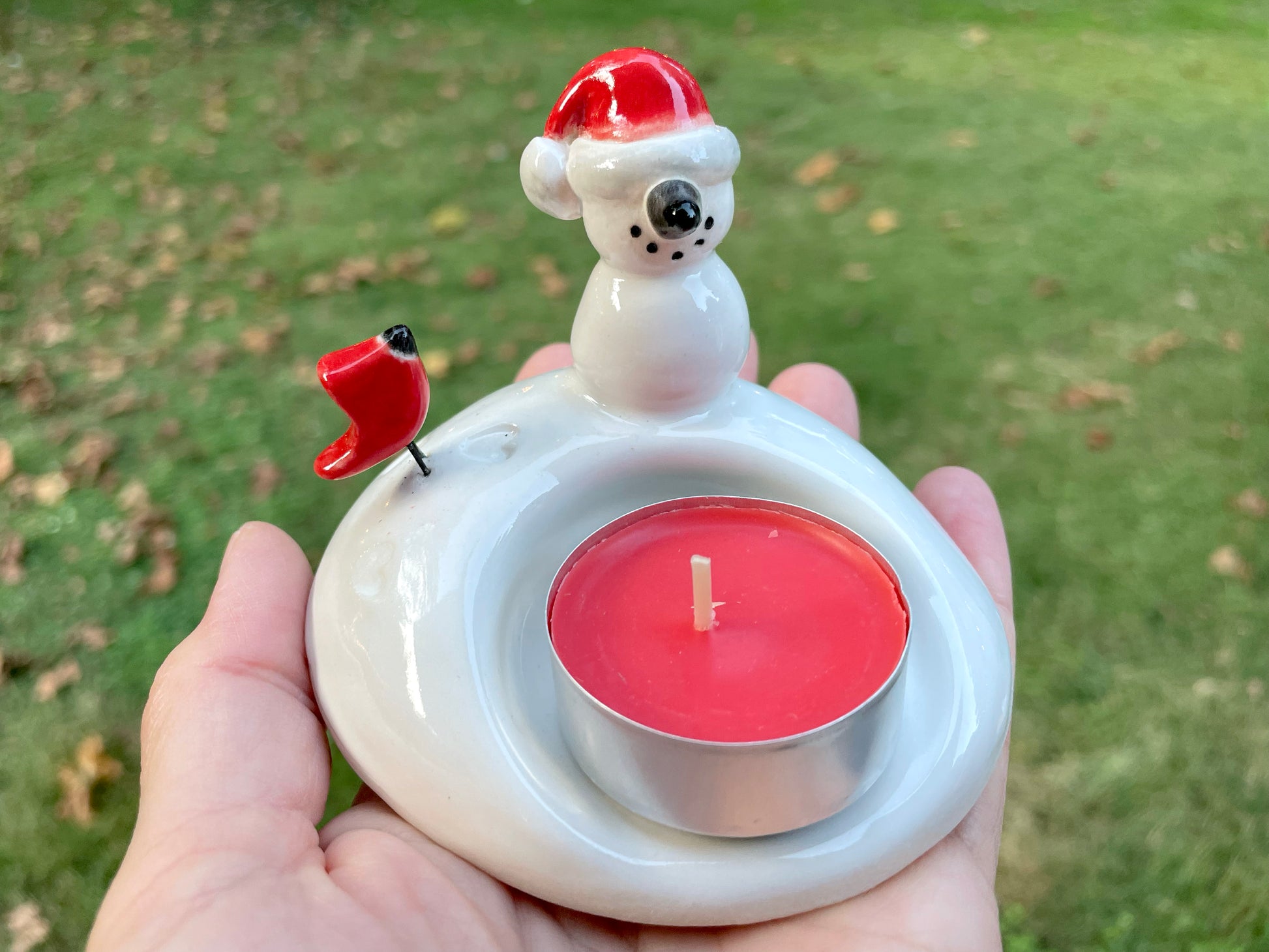 Ceramic snowman and cardinal candle holder, perfect Christmas home accent.