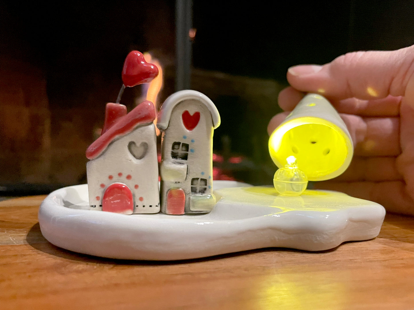 LED light feature: "Ceramic mini village with LED light projecting warm glow through tree and houses