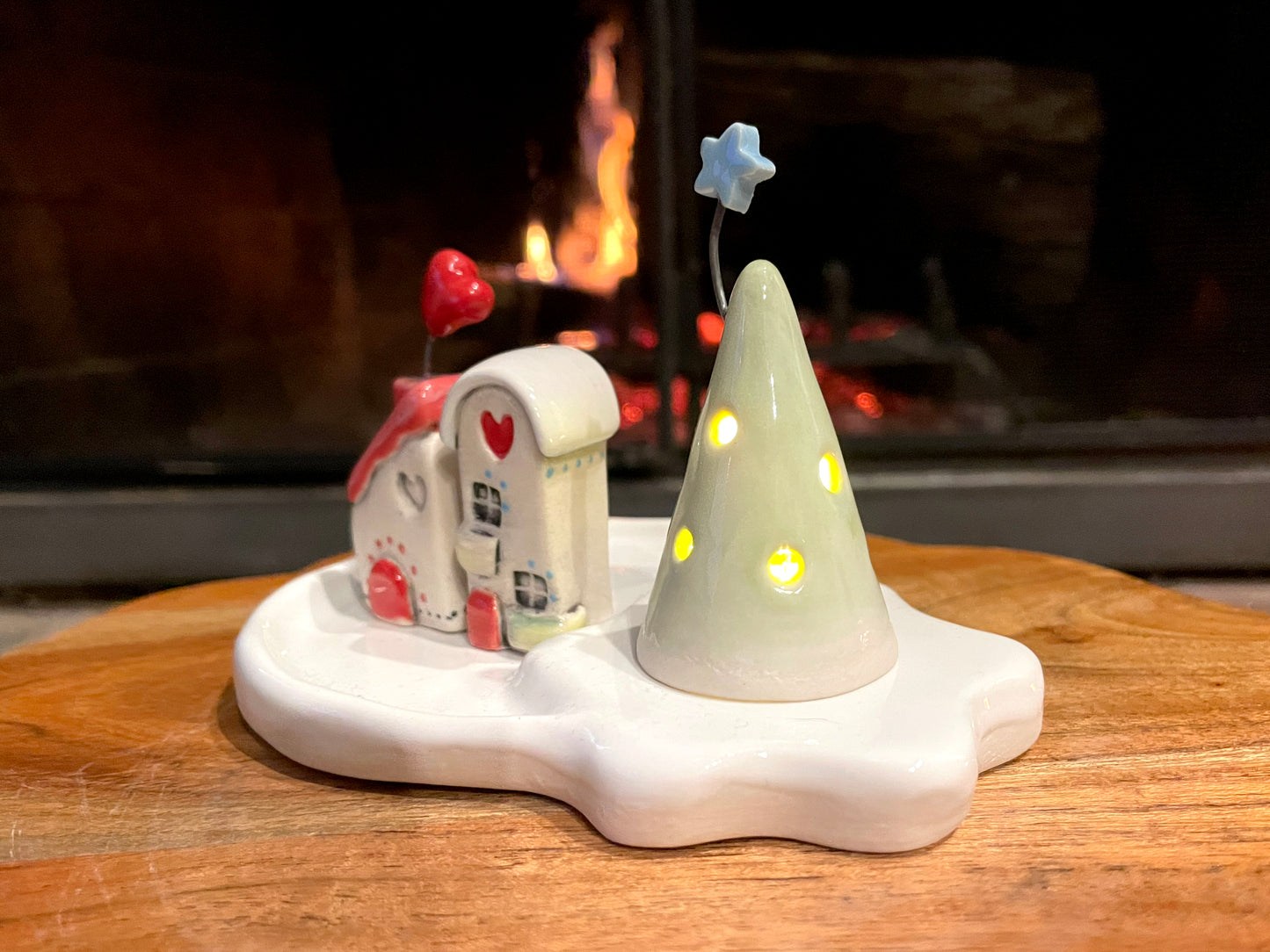 Ceramic mini village set displayed on mantel as holiday home decor with LED lighting