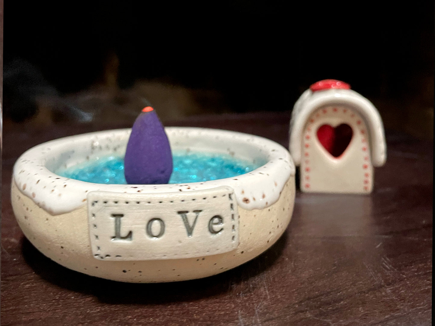 Cozy handmade Christmas house set glowing softly — winter pottery decoration.