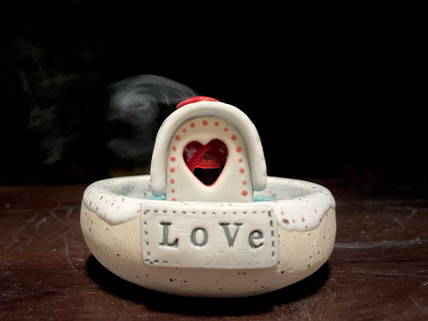 Cozy handmade Christmas house set glowing softly — winter pottery decoration.