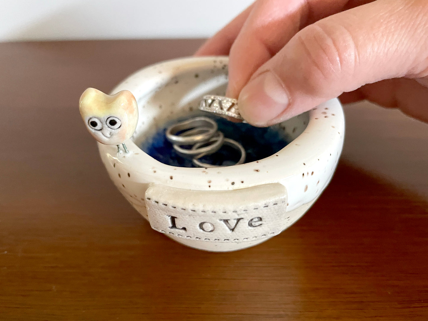 Jewelry and candle holder combo dish handmade in clay with red bird detail. Ceramic bird-shaped ring holder with 'Love' on 