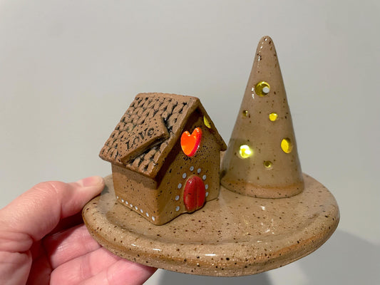 Ceramic house and cone with glowing eyes on a gray background