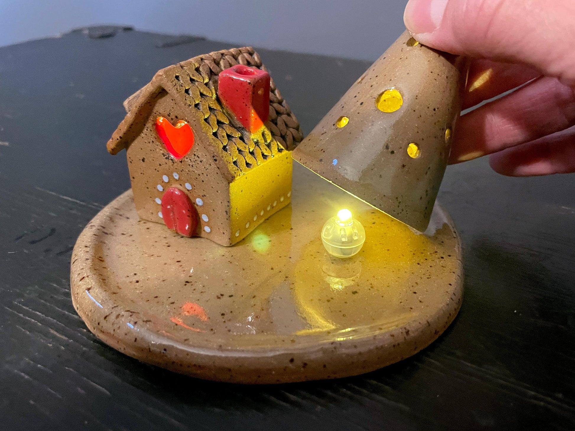 Ceramic house with a light inside on a dark surface